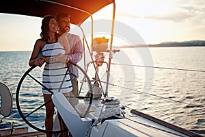 Romantic couple sailing on the luxury boat together and enjoy at sunset