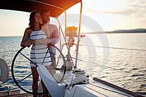 Romantic couple sailing on the luxury boat together and enjoy at sunset photo