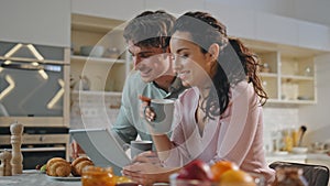 Romantic couple shopping online at family breakfast close up. Pair using gadget