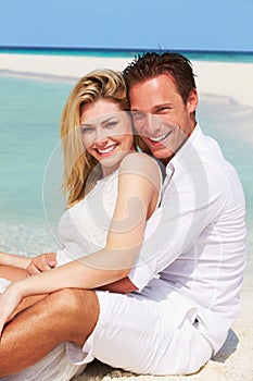 Romantic Couple Sitting On Beautiful Tropical Beach