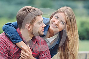 Romantic couple sitting on bench, hugging and smiling