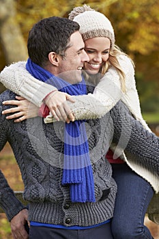 Romantic Couple Sitting On Fence In Autumn Woodland