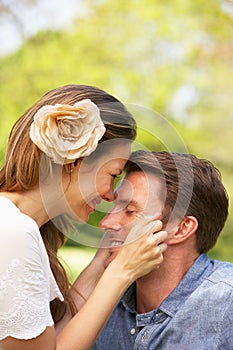 Romantic Couple Sitting In Field Of Summer Flowers