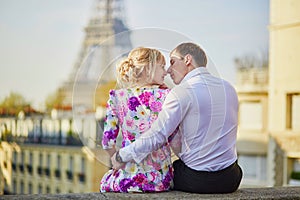 Romantic couple sitting on the roof near the Eiffel tower in Paris, France