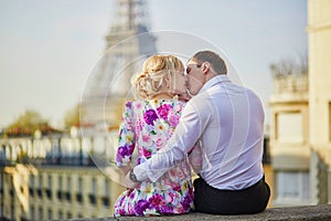 Romantic couple sitting on the roof near the Eiffel tower in Paris, France