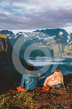 Romantic couple in sleeping bags on bivouac travel in Norway mountains with camping travel gear photo