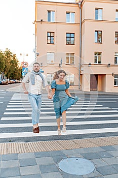 Romantic couple spending time together in the city and jumping while on a crosswalk.