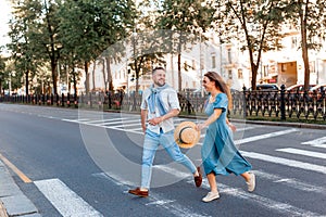 Romantic couple spending time together in the city while walking on a crosswalk.