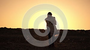 Romantic couple spinning hugging on sunset background