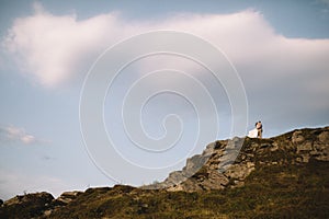 Romantic couple standing together holding hands in the mountains