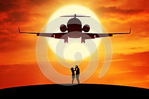Romantic couple standing under flying aircraft