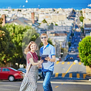 Couple of tourists using tablet and planning their itinerary in San Francisco, California, USA