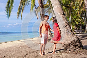 Romantic couple at tropical beach near palm tree