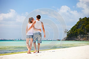 Romantic couple walking along tropical beach