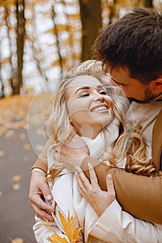 Romantic couple walking in autumn forest and hugging