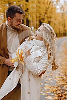 Romantic couple walking in autumn forest and hugging