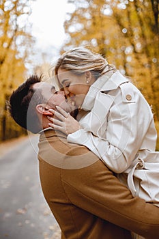 Romantic couple walking in autumn forest and kissing