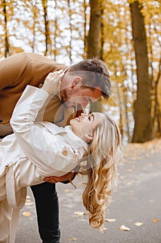 Romantic couple walking in autumn forest and kissing