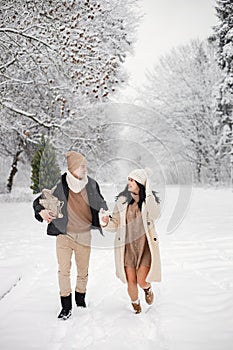 Romantic couple walking in forest at winter day