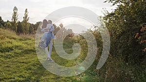 Romantic couple walking in park. Portrait of happy man and woman spending time and hugging at summer outdoors.