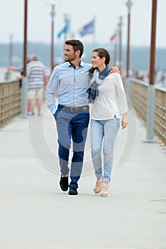 Romantic couple walking on pier nea sea