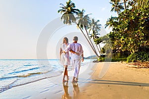 Romantic couple walking together on tropical beach, sunny summer honeymoon