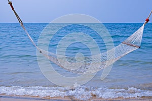 Romantic cozy hammock on the tropical beach by the sea. Peaceful seascape. Relax, travel concept, travelling.