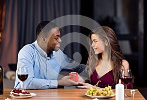 Romantic Date. Loving Black Man Giving Gift Box To His White Girlfriend