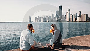 Romantic date on the shore of Michigan lake in Chicago, America. Beautiful couple enjoying a picnic together.