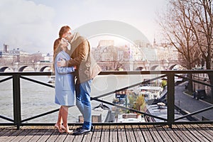 Romantic dating, young couple kissing on the bridge in Paris