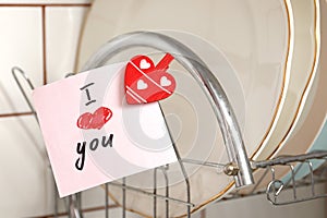 Romantic declaration of love on a sticky note in the interior of the kitchen. Love confession. Valentine`s day celebration. Stick