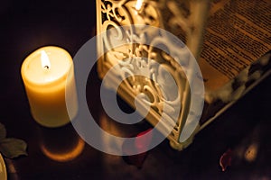 Romantic decoration, candle and white beautiful container metal wrought iron box with rose petals on the reflected black marble