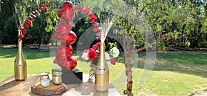 Romantic decoration with flowers and red hearts outdoors in forest vegetation. day of love