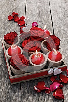 Romantic decoration with roses and scented candles in wooden box