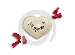 Romantic dessert in the shape of a heart with text I love you in Spanish and rose petals isolated on white. St. Valentine`s Day