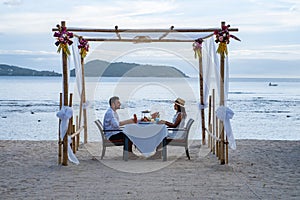 Romantic dinner on the beach, couple man and woman mid age having a romantic dinner on the beach in Phuket Thailand