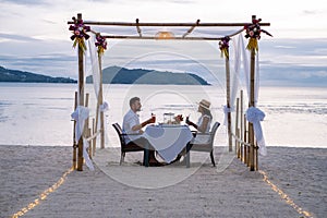 Romantic dinner on the beach, couple man and woman mid age having a romantic dinner on the beach in Phuket Thailand