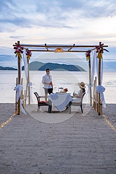 Romantic dinner on the beach, couple man and woman mid age having a romantic dinner on the beach in Phuket Thailand