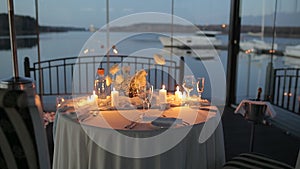 Romantic dinner on the beach. Outdoor restaurant table dinner setting on the beach at dusk