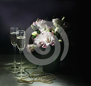 Romantic dinner with bouquet of flowers, candles and champagne glasses.