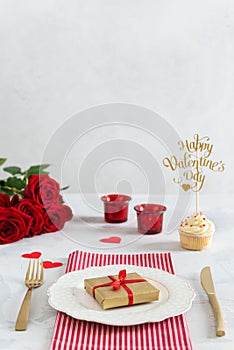 Romantic dinner concept. St Valentine`s day or proposal background. Romantic gift on the white plate on restaurant table with
