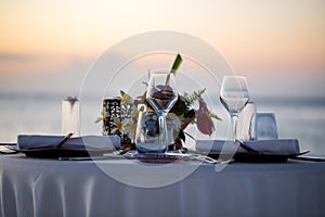 Romantic dinner setting on the beach at sunset.