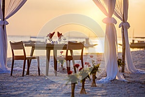 Romantic dinner setting on the beach at sunset