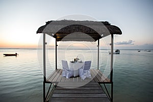 Romantic dinner setting on the beach at sunset.
