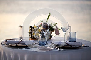 Romantic dinner setting on the beach at sunset.