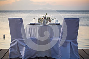 Romantic dinner setting on the beach at sunset.