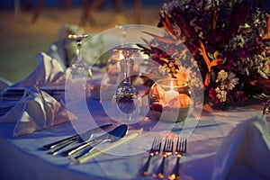 Romantic dinner setting on the beach at sunset