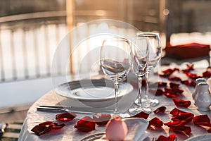Romantic dinner setup, red decoration with rose petals in a restaurant