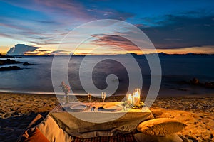 Romantic Dinner Table set beside the beach in the sunset twilight time, at Munnok Island, Thailand