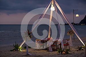 Romantic dinning table on the beach . Table setting at a luxury wedding and Beautiful flowers on the table.